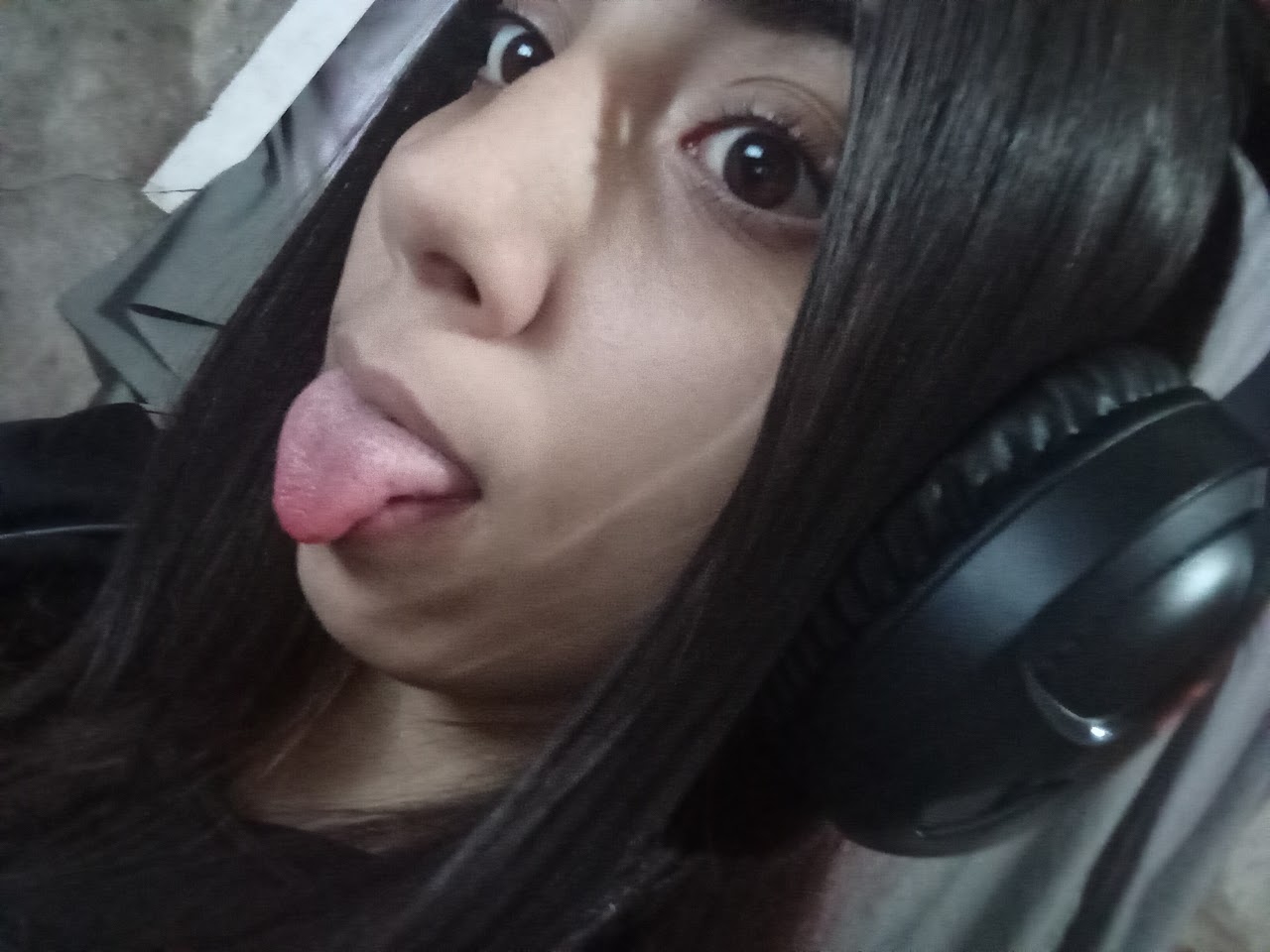 Delfi con auriculares sacando la lengua